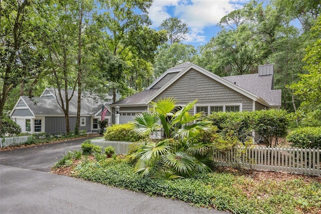 5434 SW 91st Ter, Gainesville, FL 32608 - view of front of property with asphalt driveway, a garage, a chimney, and a shingled roof