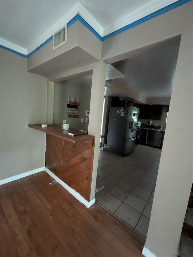5768 SW 52nd Ter, Lake Butler, FL 32054 - kitchen with ornamental molding, wood finished floors, baseboards, and stainless steel fridge with ice dispenser
