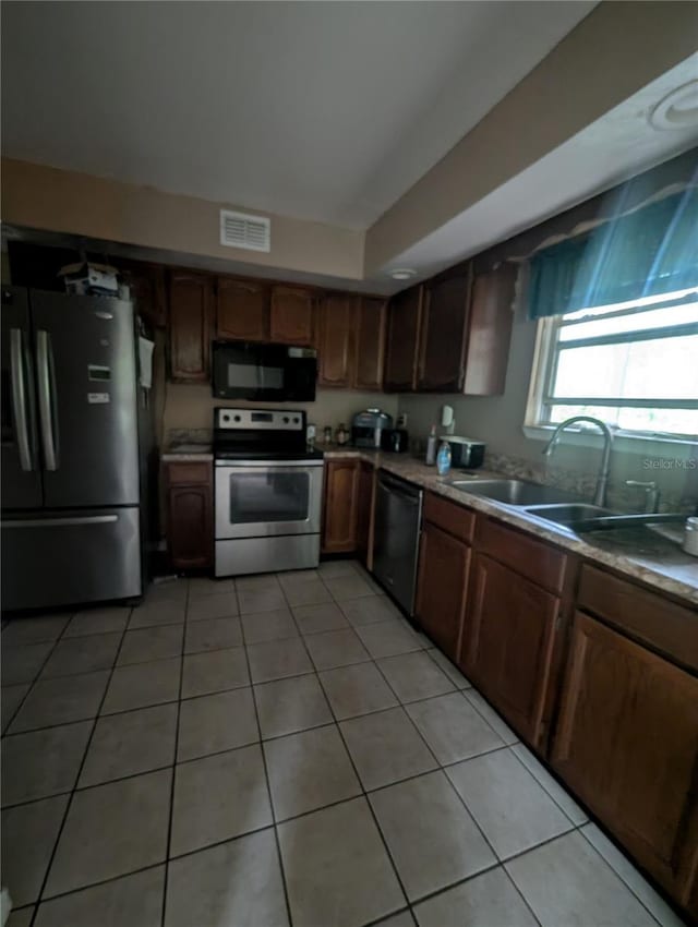 5768 SW 52nd Ter, Lake Butler, FL 32054 - kitchen featuring stainless steel appliances, a sink, light tile patterned flooring, and light countertops