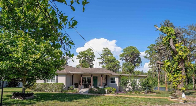 18101 Boy Scout Rd, Odessa, FL 33556 - view of front of house featuring covered porch, a front lawn, and stucco siding
