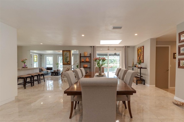 18101 Boy Scout Rd, Odessa, FL 33556 - dining area featuring plenty of natural light, baseboards, recessed lighting, light marble finish flooring, and a skylight