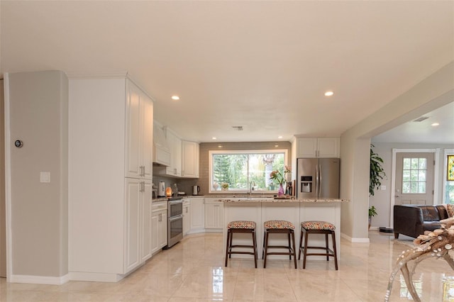 18101 Boy Scout Rd, Odessa, FL 33556 - kitchen with appliances with stainless steel finishes, recessed lighting, a kitchen breakfast bar, baseboards, and white cabinetry