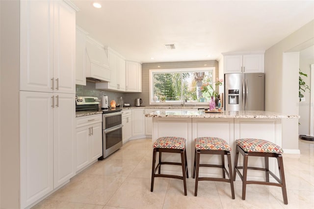 18101 Boy Scout Rd, Odessa, FL 33556 - kitchen with stainless steel appliances, tasteful backsplash, a breakfast bar, a sink, and white cabinets