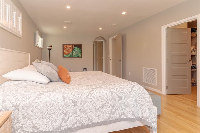18101 Boy Scout Rd, Odessa, FL 33556 - bedroom featuring arched walkways, light wood-type flooring, recessed lighting, and baseboards