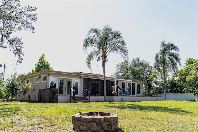 18101 Boy Scout Rd, Odessa, FL 33556 - back of house with a fire pit, a sunroom, a lawn, and stucco siding