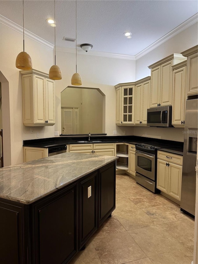 1848 NW 34th St Unit 23, Gainesville, FL 32605 - kitchen featuring appliances with stainless steel finishes, cream cabinetry, ornamental molding, a sink, and decorative light fixtures