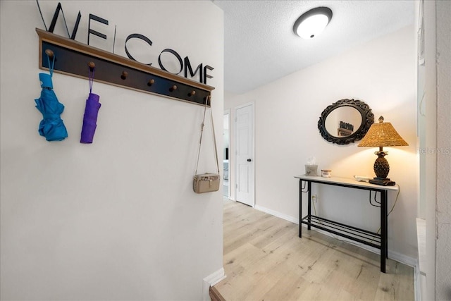 10000 SW 52nd Ave Unit 120, Gainesville, FL 32608 - hall with wood finished floors, baseboards, and a textured ceiling