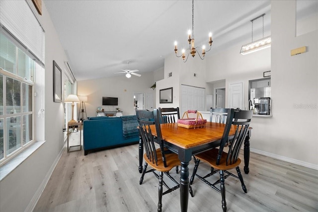 10000 SW 52nd Ave Unit 120, Gainesville, FL 32608 - dining space featuring a ceiling fan, light wood-style flooring, high vaulted ceiling, baseboards, and a chandelier