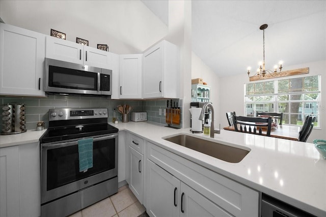 10000 SW 52nd Ave Unit 120, Gainesville, FL 32608 - kitchen with stainless steel appliances, a sink, lofted ceiling, a chandelier, and light countertops