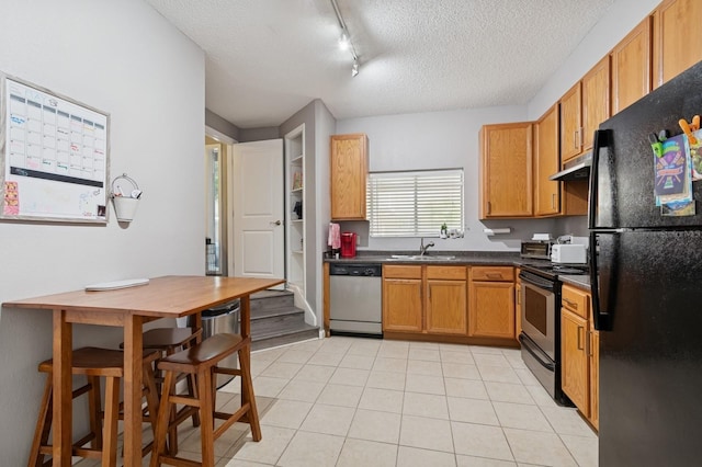 507 NW 39th Rd Unit 154, Gainesville, FL 32607 - kitchen with stainless steel appliances, under cabinet range hood, a textured ceiling, rail lighting, and a sink
