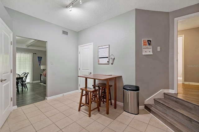 507 NW 39th Rd Unit 154, Gainesville, FL 32607 - dining room with light tile patterned flooring, baseboards, a textured ceiling, and rail lighting