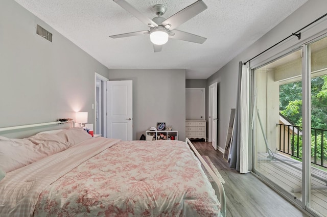 507 NW 39th Rd Unit 154, Gainesville, FL 32607 - bedroom with access to outside, light wood-style flooring, a textured ceiling, a ceiling fan, and baseboards