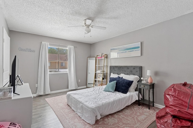 507 NW 39th Rd Unit 154, Gainesville, FL 32607 - bedroom with wood finished floors, a textured ceiling, baseboards, and ceiling fan