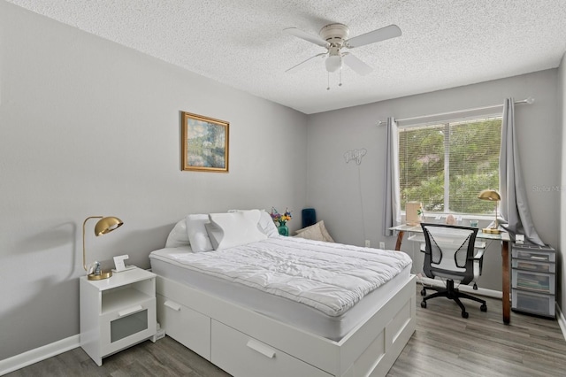 507 NW 39th Rd Unit 154, Gainesville, FL 32607 - bedroom with a textured ceiling, wood finished floors, a ceiling fan, baseboards, and a desk
