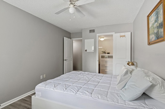 507 NW 39th Rd Unit 154, Gainesville, FL 32607 - bedroom with dark wood-style floors, a textured ceiling, ceiling fan, and baseboards