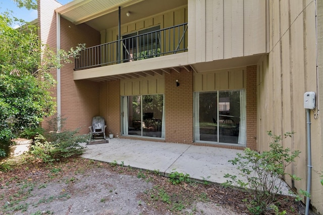 507 NW 39th Rd Unit 154, Gainesville, FL 32607 - rear view of house with brick siding, a patio area, and a balcony