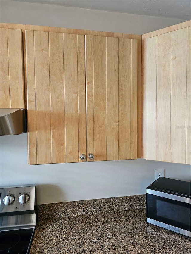 4007 SW 26th Ter Unit B, Gainesville, FL 32608 - kitchen view of light brown cabinets, range with electric cooktop, stainless steel microwave, and dark stone countertops