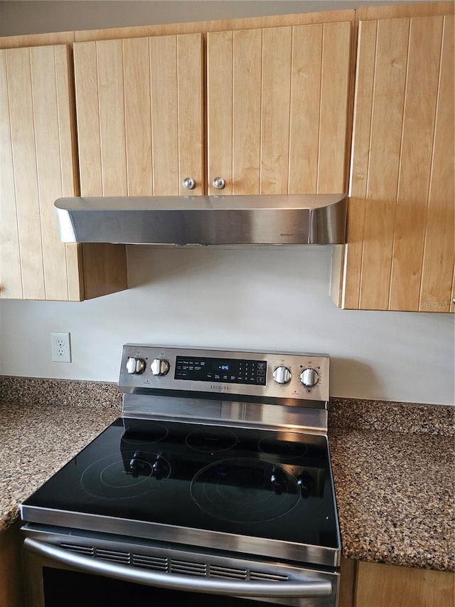 4007 SW 26th Ter Unit B, Gainesville, FL 32608 - kitchen view of stainless steel range with electric stovetop, light brown cabinets, under cabinet range hood, and dark stone counters
