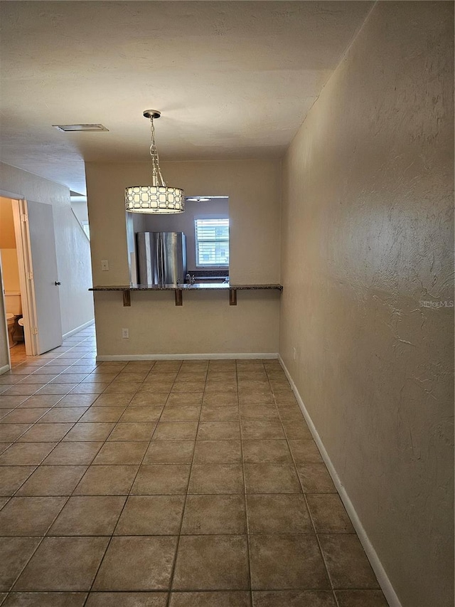 4007 SW 26th Ter Unit B, Gainesville, FL 32608 - spare room with baseboards and dark tile patterned flooring