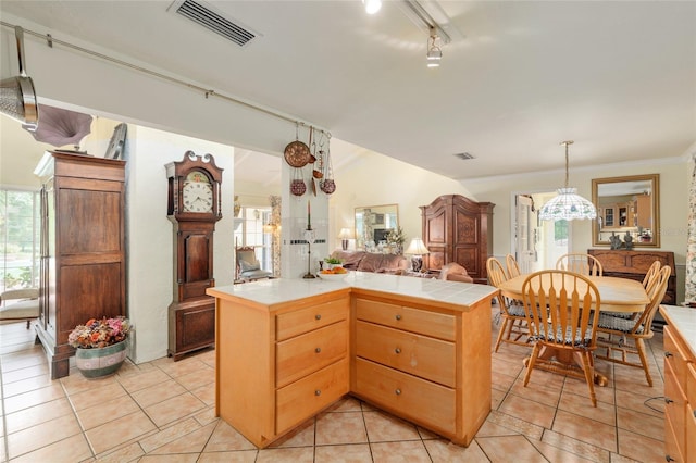 12832 SW 14th Ave, Newberry, FL 32669 - kitchen with tile counters, light tile patterned floors, open floor plan, hanging light fixtures, and crown molding