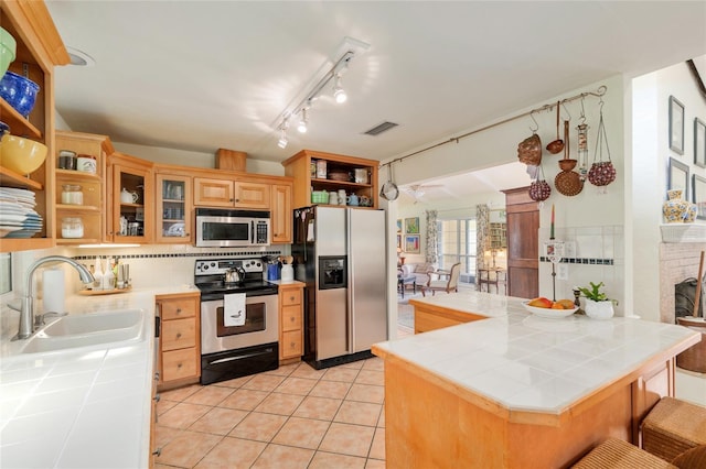 12832 SW 14th Ave, Newberry, FL 32669 - kitchen with stainless steel appliances, tile counters, a sink, open shelves, and light tile patterned flooring