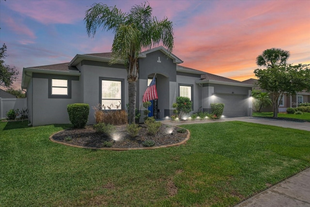 13365 Chesapeake Pl, Spring Hill, FL 34609 - view of front of home with stucco siding, driveway, a yard, and an attached garage