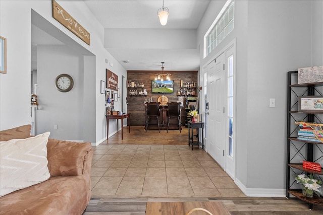 13365 Chesapeake Pl, Spring Hill, FL 34609 - tiled foyer featuring an accent wall, baseboards, and a chandelier