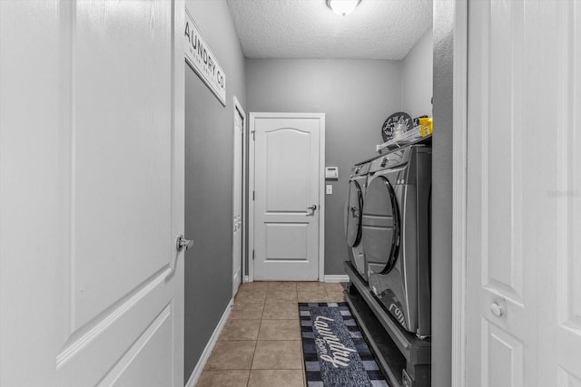 13365 Chesapeake Pl, Spring Hill, FL 34609 - laundry room featuring washing machine and dryer, a textured ceiling, light tile patterned flooring, and baseboards