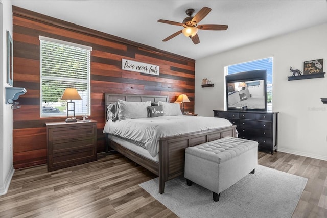 13365 Chesapeake Pl, Spring Hill, FL 34609 - bedroom with wooden walls, light wood finished floors, a ceiling fan, baseboards, and an accent wall