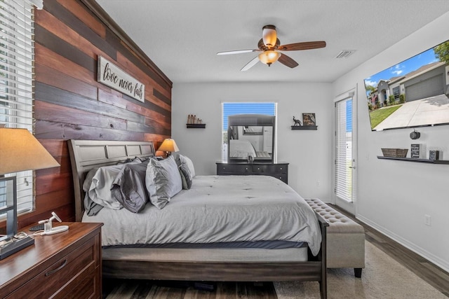 13365 Chesapeake Pl, Spring Hill, FL 34609 - bedroom featuring wood walls, multiple windows, wood finished floors, and ceiling fan