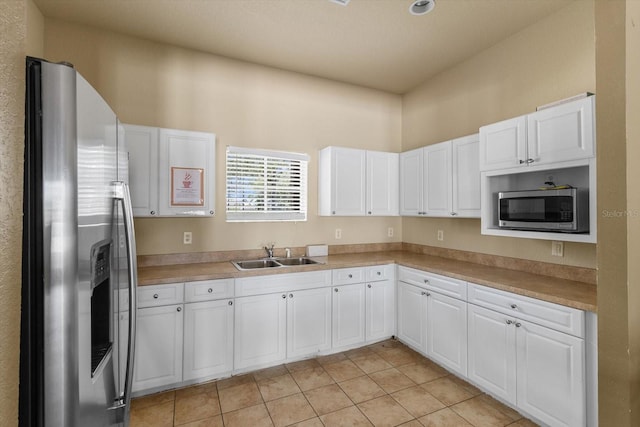 13365 Chesapeake Pl, Spring Hill, FL 34609 - kitchen with appliances with stainless steel finishes, a sink, white cabinets, light tile patterned floors, and light countertops