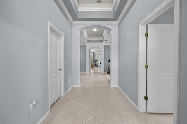 923 SW 85th Way, Gainesville, FL 32607 - hall with arched walkways, a tray ceiling, ornamental molding, light tile patterned flooring, and baseboards