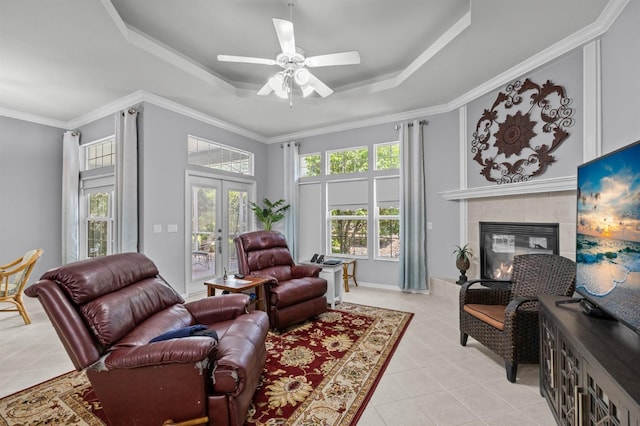 923 SW 85th Way, Gainesville, FL 32607 - living room featuring light tile patterned floors, a raised ceiling, a tiled fireplace, ceiling fan, and french doors