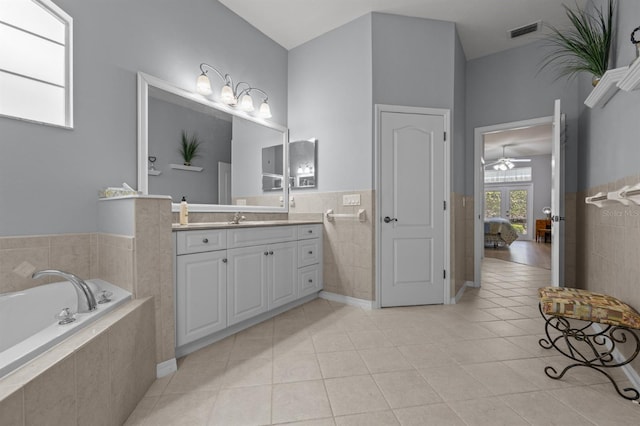 923 SW 85th Way, Gainesville, FL 32607 - ensuite bathroom featuring vanity, a bath, tile patterned flooring, tile walls, and ceiling fan