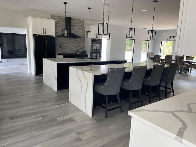 2518 Sunset Ln, Lutz, FL 33559 - kitchen with a large island with sink, ventilation hood, black appliances, decorative backsplash, and white cabinets
