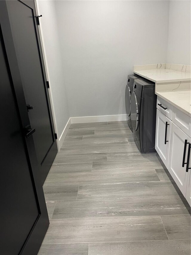 2518 Sunset Ln, Lutz, FL 33559 - laundry area with separate washer and dryer, cabinet space, and light wood-type flooring