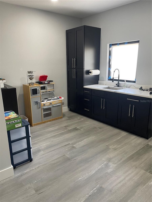 2518 Sunset Ln, Lutz, FL 33559 - kitchen with light countertops, dark cabinets, and light wood-type flooring
