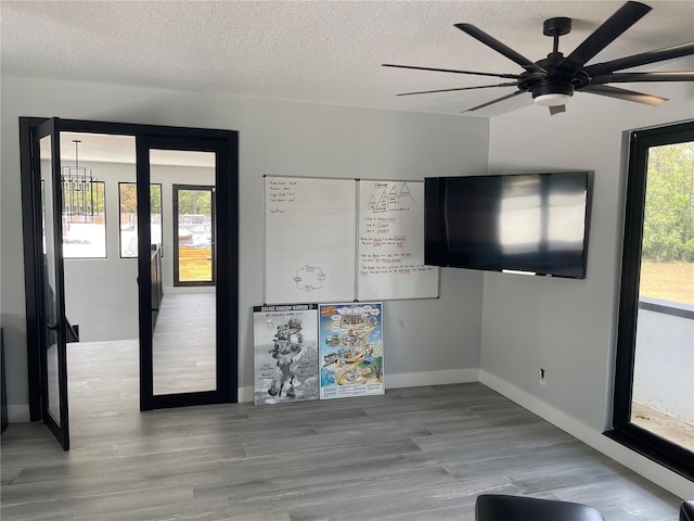 2518 Sunset Ln, Lutz, FL 33559 - unfurnished living room with healthy amount of natural light, wood finished floors, a textured ceiling, and ceiling fan