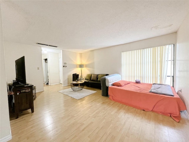 2811 SW Archer Rd Unit T164, Gainesville, FL 32608 - living area featuring a textured ceiling, light wood-style flooring, and baseboards
