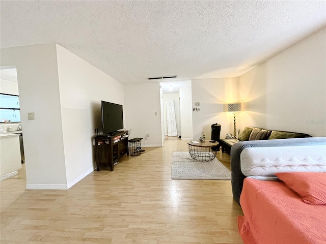 2811 SW Archer Rd Unit T164, Gainesville, FL 32608 - living room with light wood-style floors, a textured ceiling, and baseboards