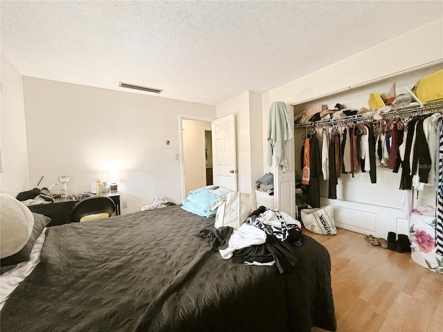 2811 SW Archer Rd Unit T164, Gainesville, FL 32608 - bedroom with wood finished floors, a closet, and a textured ceiling