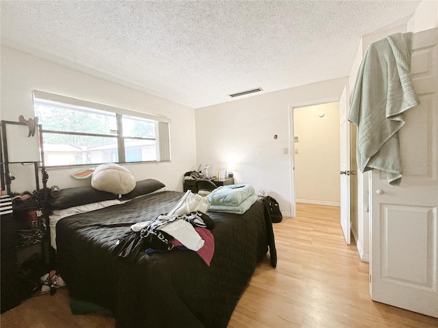 2811 SW Archer Rd Unit T164, Gainesville, FL 32608 - bedroom with light wood-style flooring and a textured ceiling
