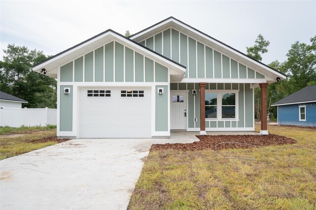 5670 NE 140th Ct, Williston, FL 32696 - view of front facade featuring board and batten siding, an attached garage, concrete driveway, and covered porch