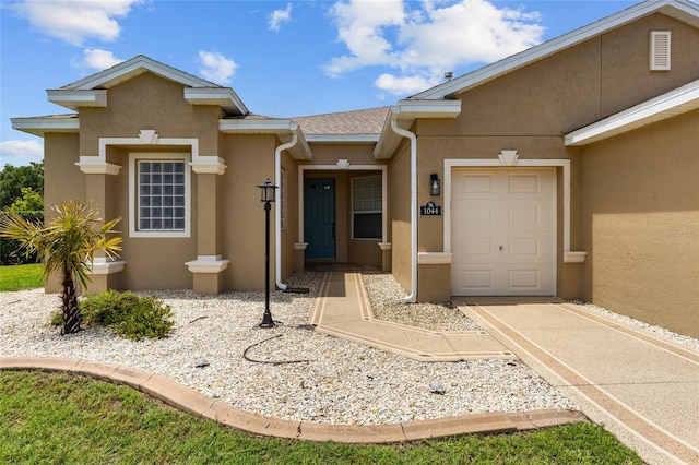 1044 SW 159th St, Ocala, FL 34473 - view of exterior entry with stucco siding, an attached garage, and driveway