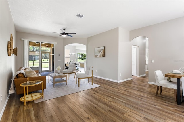 1044 SW 159th St, Ocala, FL 34473 - living room featuring arched walkways, wood finished floors, a ceiling fan, and baseboards
