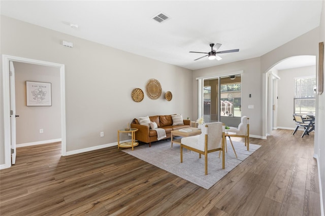 1044 SW 159th St, Ocala, FL 34473 - living room with arched walkways, ceiling fan, wood finished floors, and baseboards