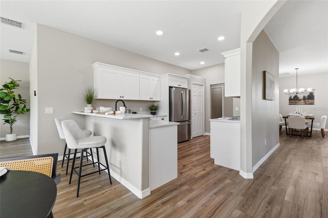 1044 SW 159th St, Ocala, FL 34473 - kitchen with freestanding refrigerator, a breakfast bar, light countertops, light wood-style flooring, and recessed lighting