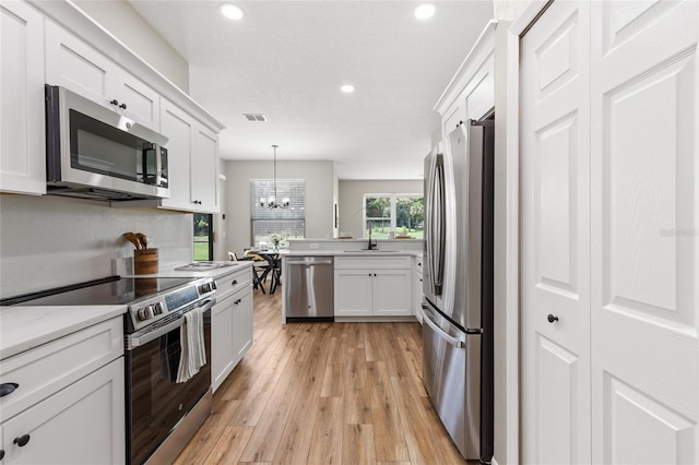 1044 SW 159th St, Ocala, FL 34473 - kitchen featuring appliances with stainless steel finishes, a chandelier, light wood-style floors, white cabinetry, and recessed lighting