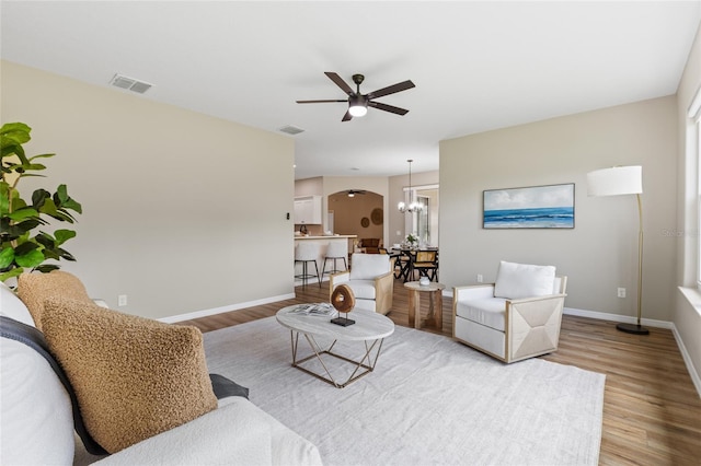 1044 SW 159th St, Ocala, FL 34473 - living area featuring wood finished floors, baseboards, ceiling fan, and arched walkways