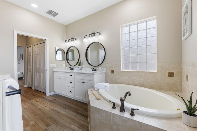 1044 SW 159th St, Ocala, FL 34473 - full bath with double vanity, a bath, wood finished floors, and baseboards
